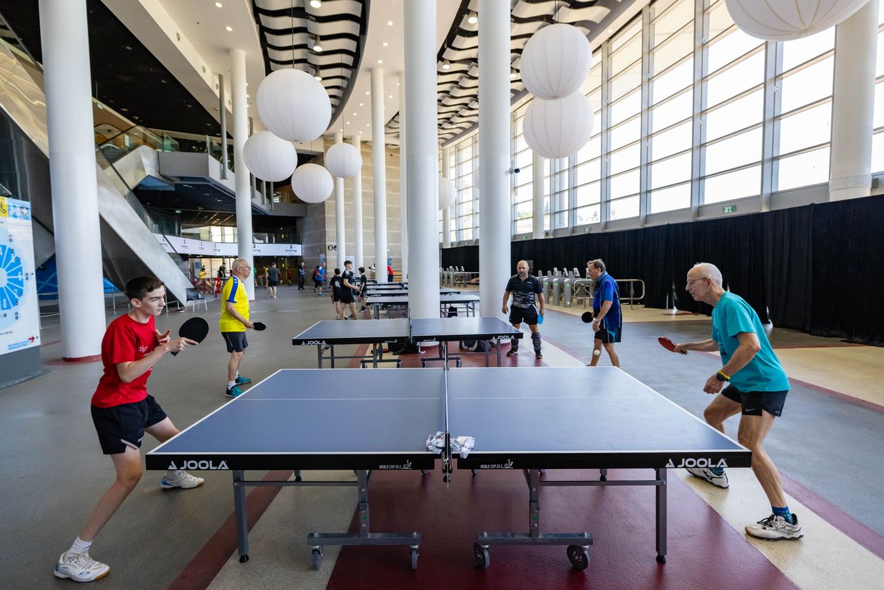 Exciting table tennis game in a modern indoor venue. Players engaged under bright lighting and stylish decor.